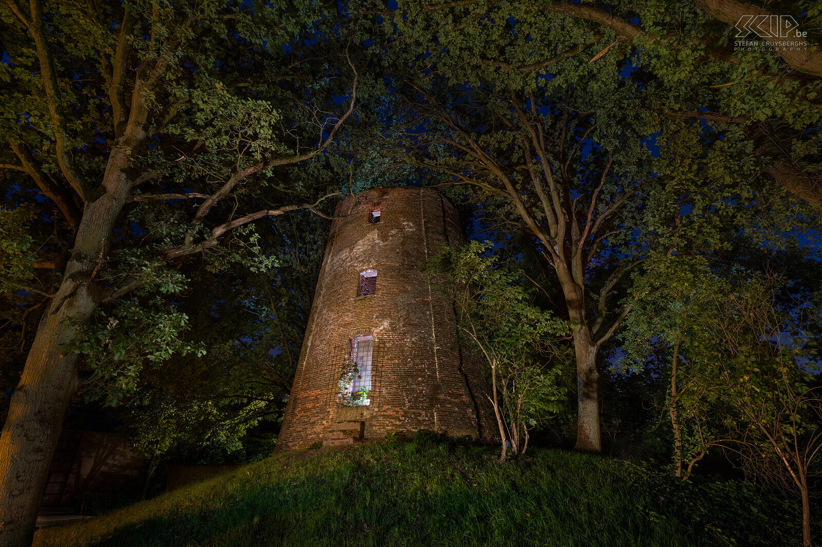 Hageland by night - Mill in Engsbergsen in Tessenderlo The mill in Engsbergsen in Tessenderlo was a grain mill that was built in 1826. The mill has not been in use since 1934 and is now a ruin that stands among the trees in a residential area. The windmill is no longer photogenic at all and yet I tried to make a few atmospheric images of it in the evening with a few flashes and LED lamps. Stefan Cruysberghs